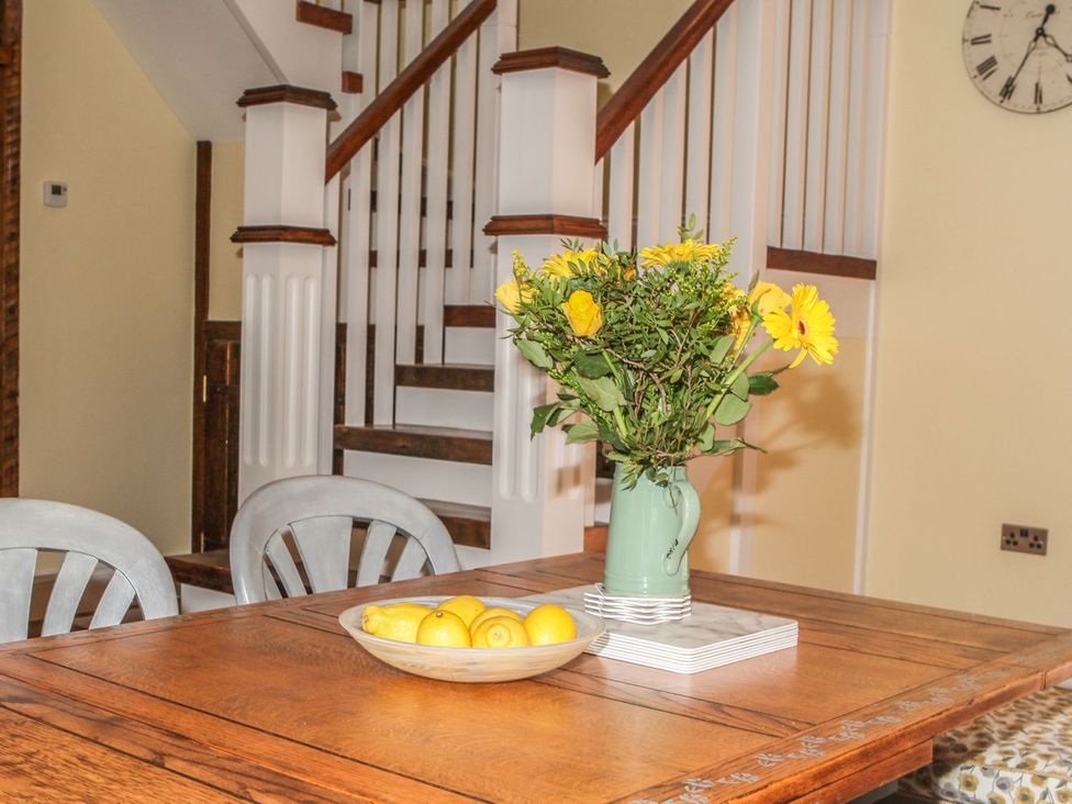 A dining room with a table and vase of flowers at The Granary in Durham
