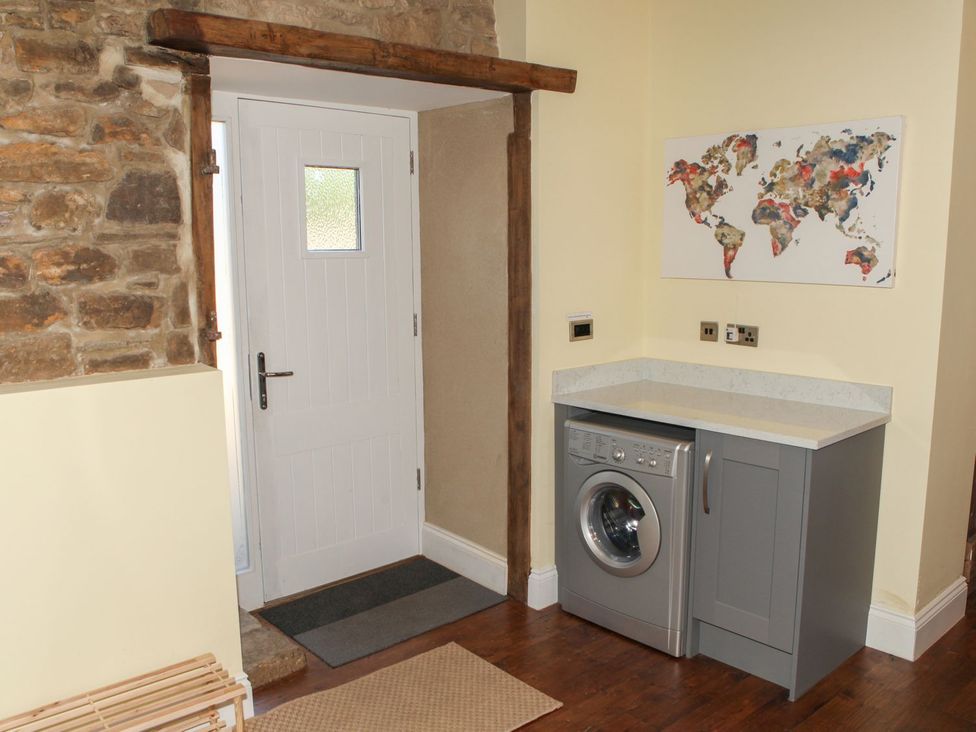 A laundry room with a washing machine and countertop at The Granary in Durham
