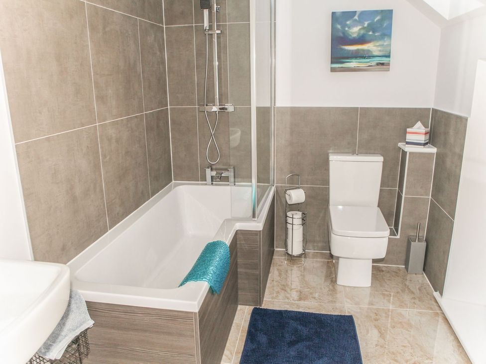 A bathroom with a bathtub, shower, toilet, and sink at The Granary in Durham