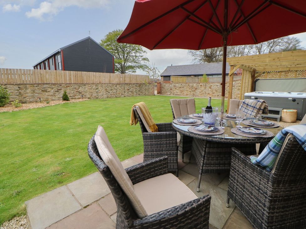 A garden with seating area and umbrella at The Granary Durham