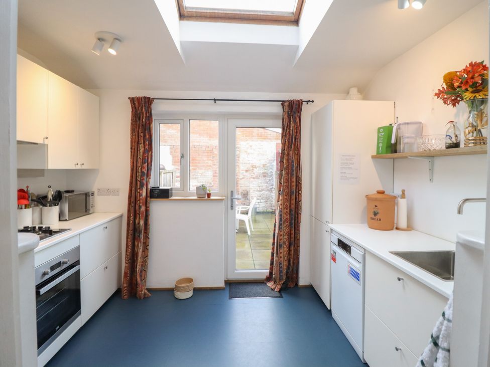 A kitchen with appliances and a door leading to an outdoor area at 32 Crescent Street Newtown