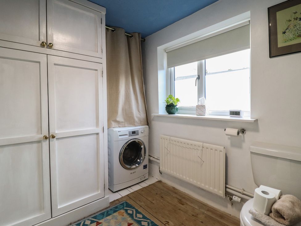 A laundry room with a washing machine and a toilet at 32 Crescent Street in Newtown