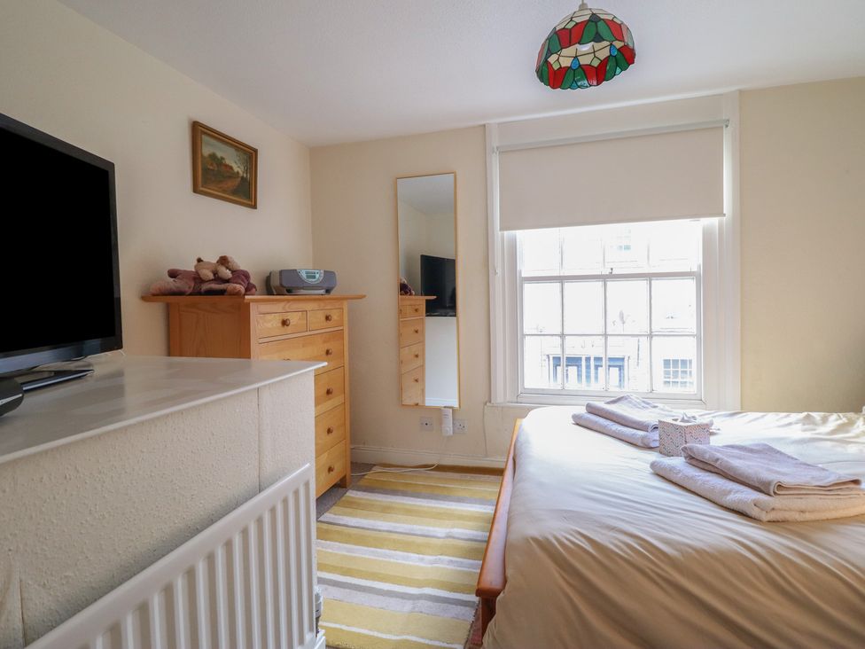 A bedroom with a bed, dresser, and TV at 32 Crescent Street in Newtown
