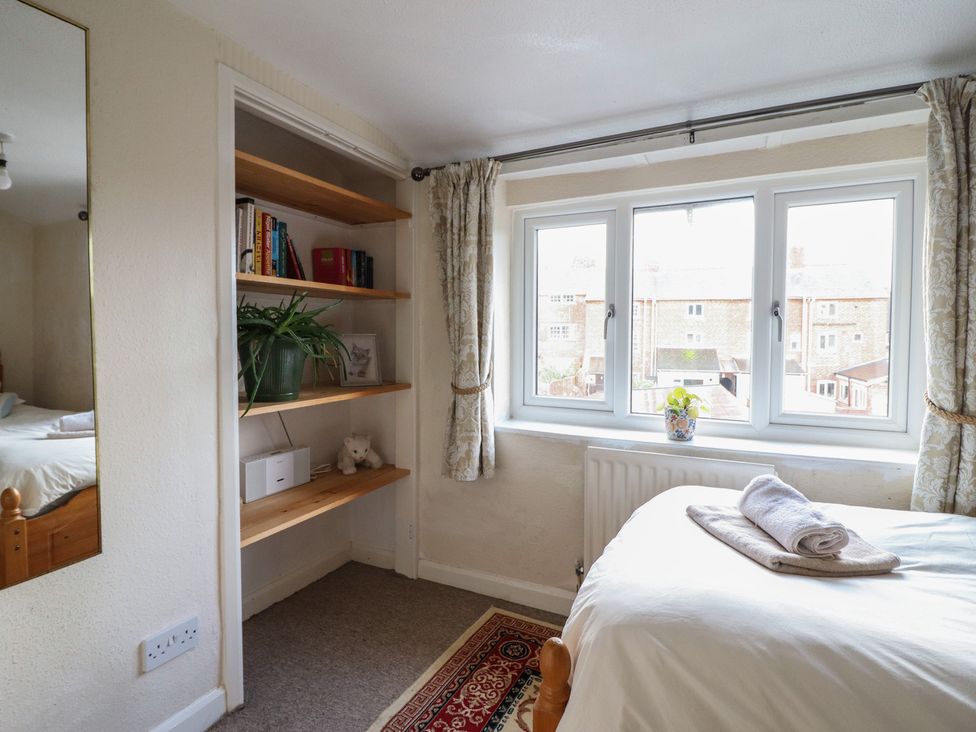 A bedroom with a bed and a shelf at 32 Crescent Street, Newtown