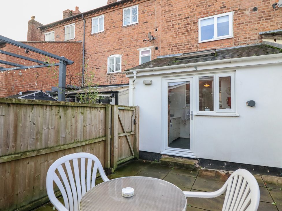 A garden with a table and chair near a door at 32 Crescent Street in Newtown