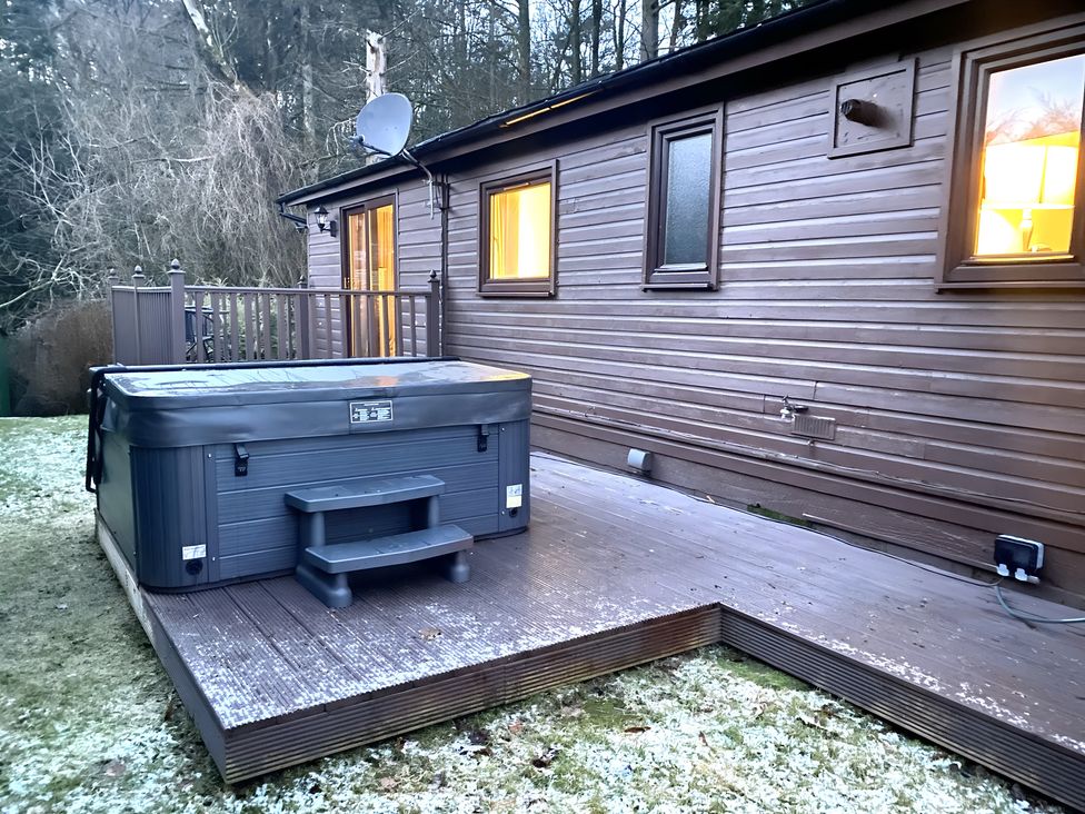 An outdoor area with a hot tub and wooden deck at Cabin 1 Moffat Manor, Moffat