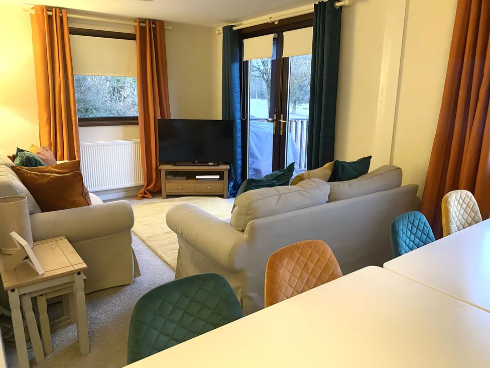 A living room with a sofa and television at Cabin 1 Moffat Manor in Moffat