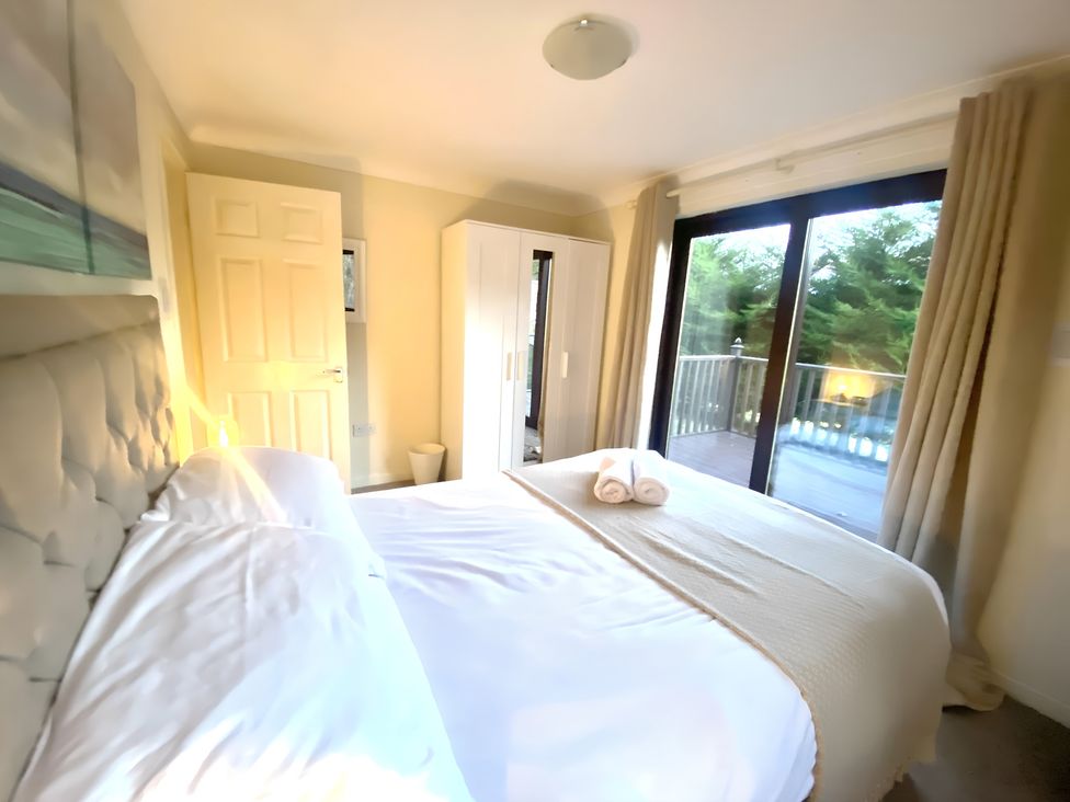 A bedroom with a bed and wardrobe at Cabin 1 Moffat Manor in Moffat
