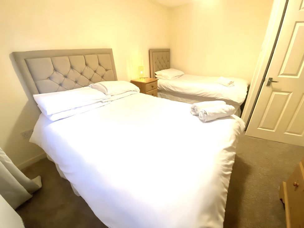 A bedroom with a double bed and a single bed at Cabin 1 Moffat Manor in Moffat