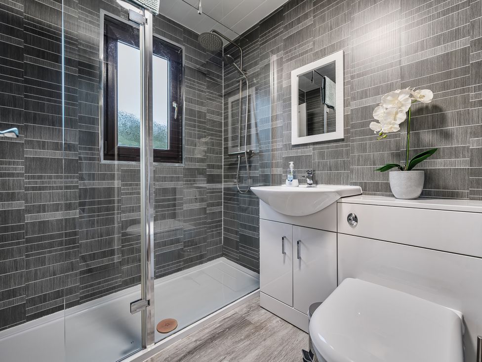 A bathroom with a shower, toilet, and wash basin at Cabin 1 Moffat Manor, Beaufort