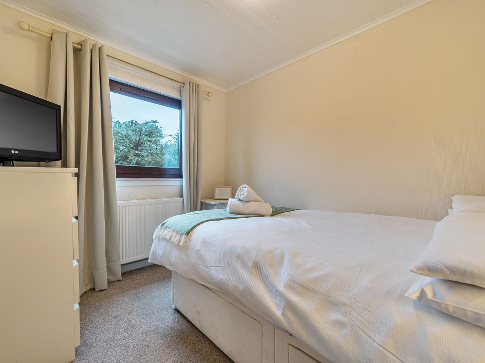 A bedroom with a bed and television at Cabin 1 Moffat Manor Beaufort