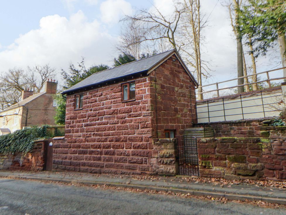 A brick building with windows and a gate at The Apple Store in Tarporley