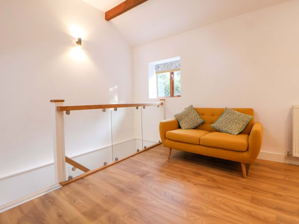 A landing with a yellow sofa and window at The Apple Store in Tarporley
