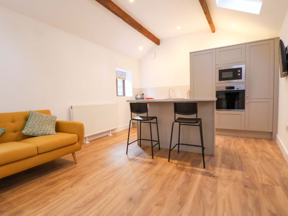 A kitchen with a sofa and bar stools at The Apple Store in Tarporley