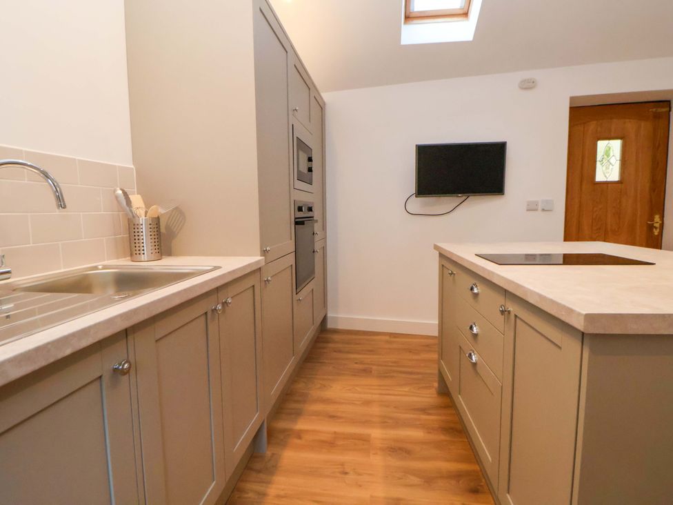 A kitchen with cabinets and appliances at The Apple Store in Tarporley