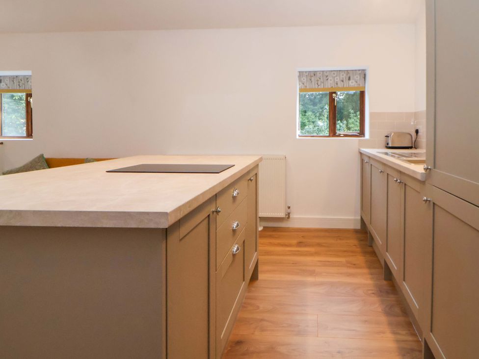 A kitchen with cabinets and a sink at The Apple Store in Tarporley