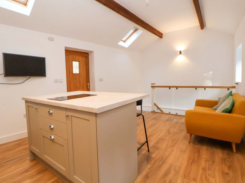 A living room with a kitchen island and sofa at The Apple Store in Tarporley