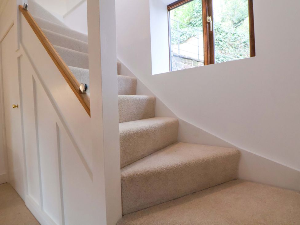 A staircase with a handrail and a window at The Apple Store in Tarporley