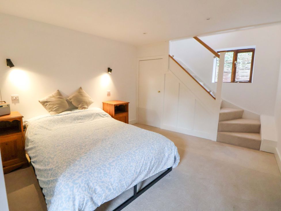 A bedroom with a bed and nightstand at The Apple Store in Tarporley
