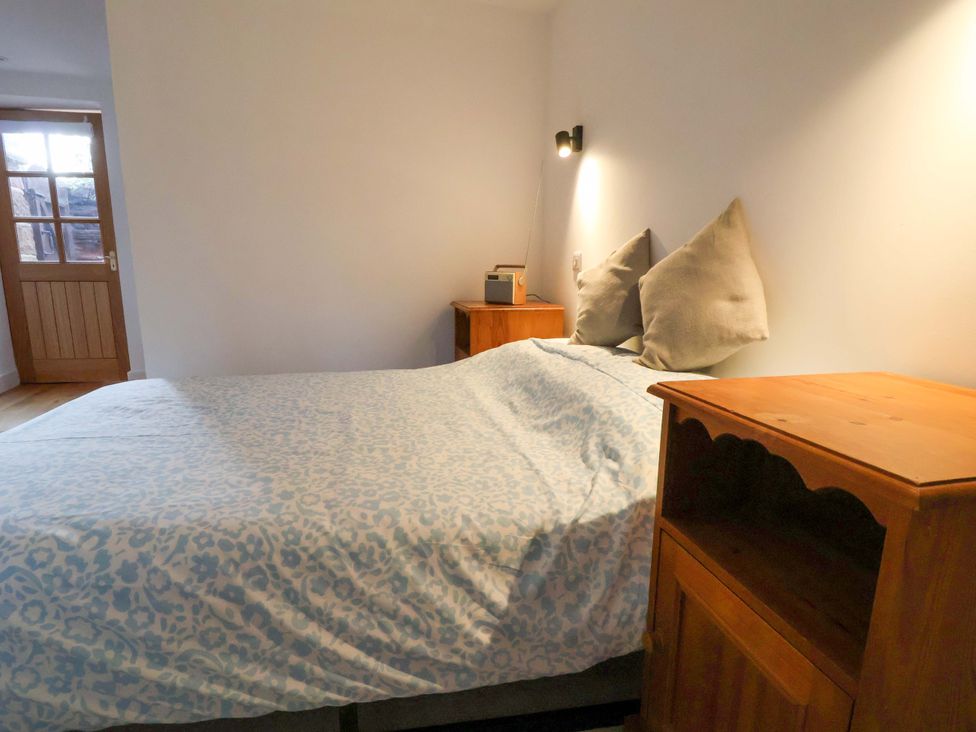 A bedroom with a bed and a nightstand at The Apple Store in Tarporley