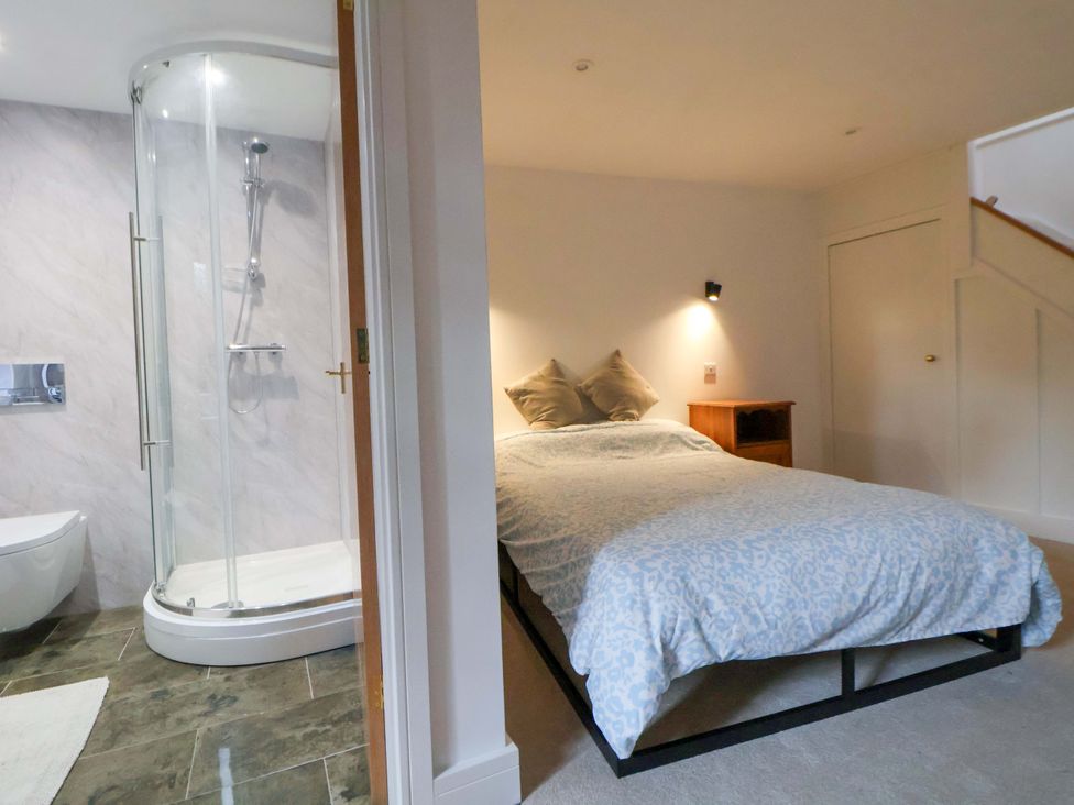 A bedroom with a bed and shower area at The Apple Store in Tarporley