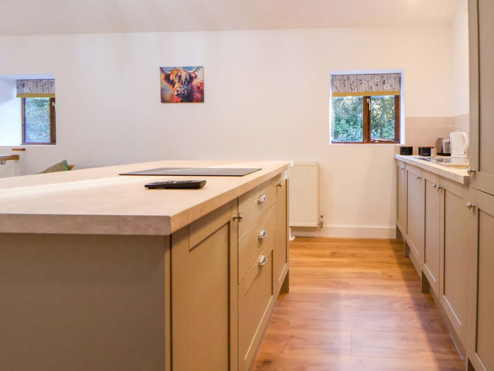 A kitchen with an island and cabinets at The Apple Store in Tarporley