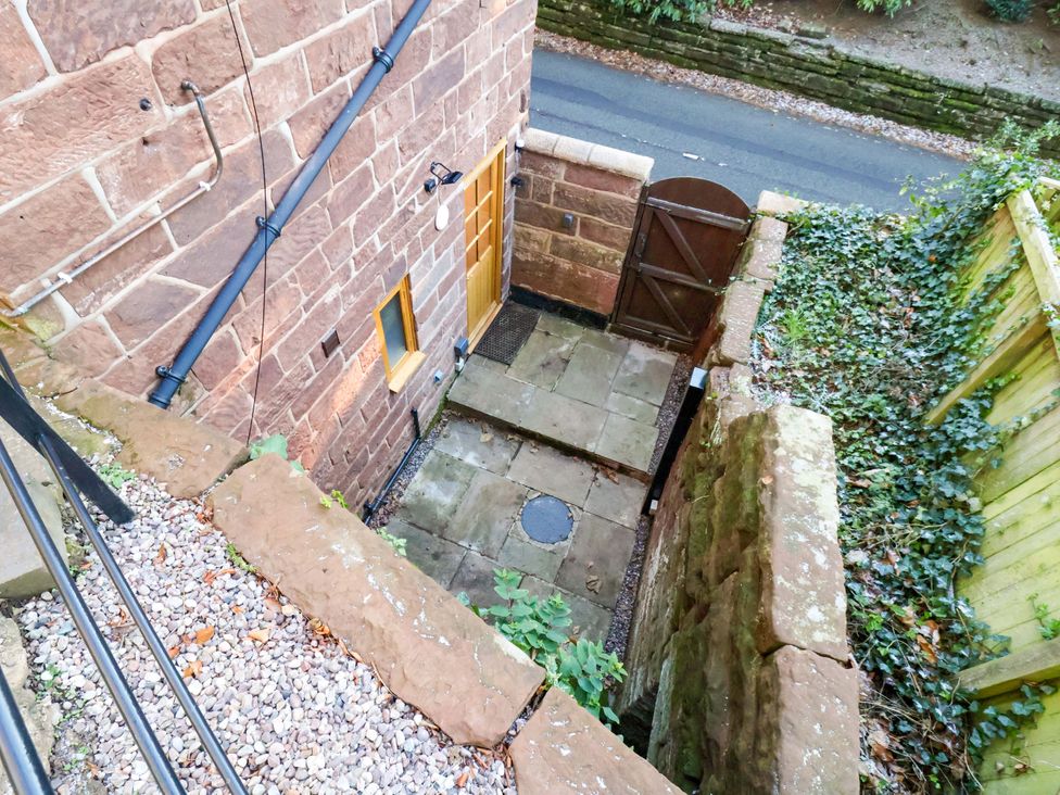 An outdoor area with stone walls and a gate at The Apple Store in Tarporley