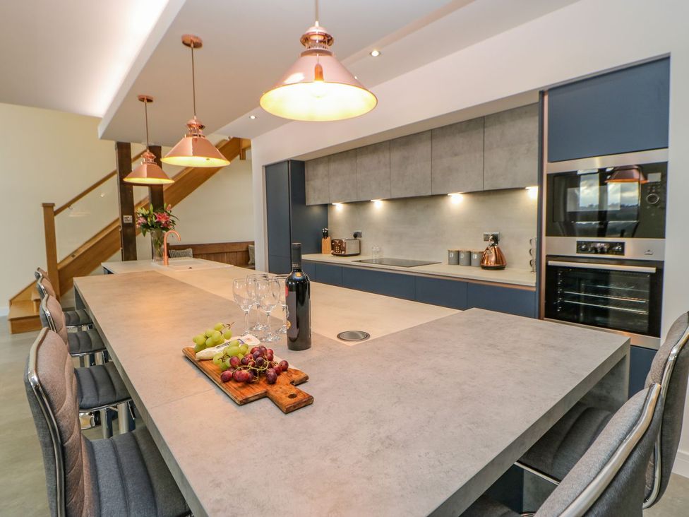 A kitchen with a large island and bar stools at Stackyard in Durham