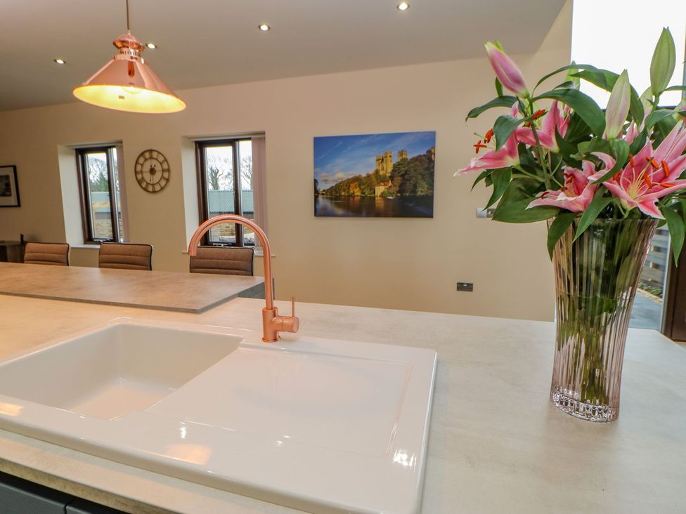 A kitchen with a sink and flowers at Stackyard in Durham