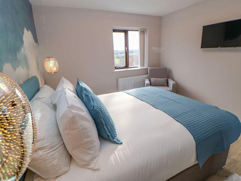 A bedroom with a double bed and armchair at Stackyard in Durham