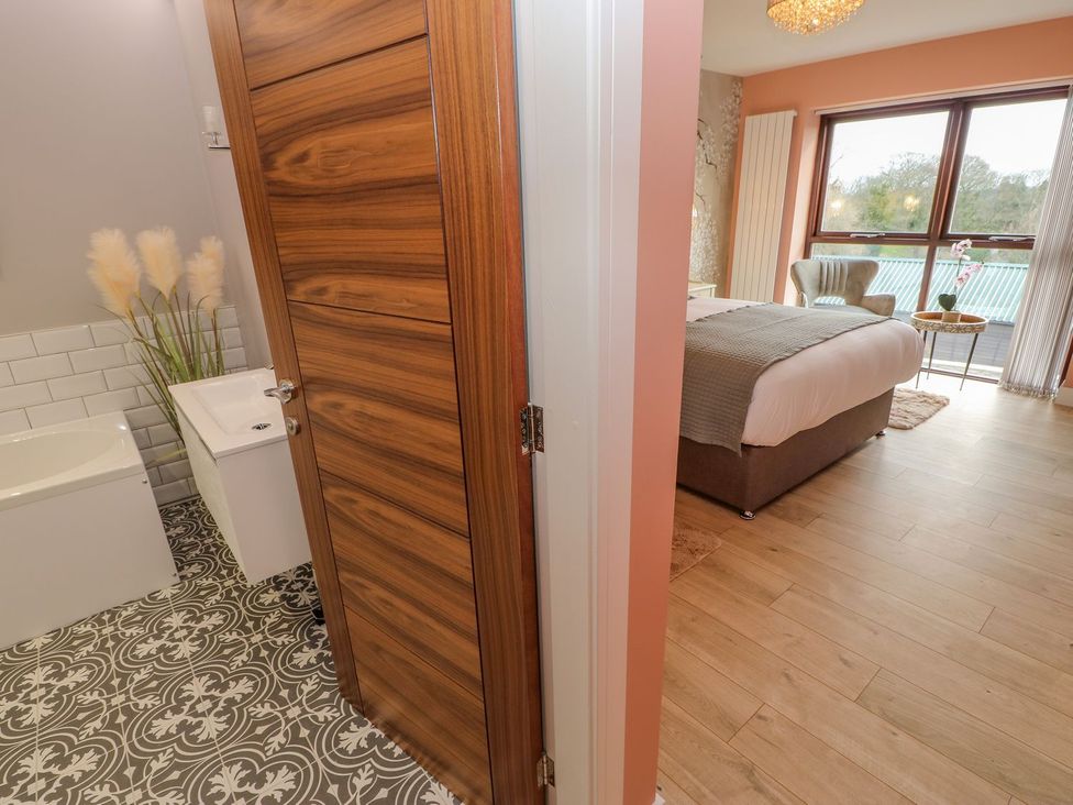 A bathroom with a bathtub and sink and a bedroom with a bed at Stackyard in Durham