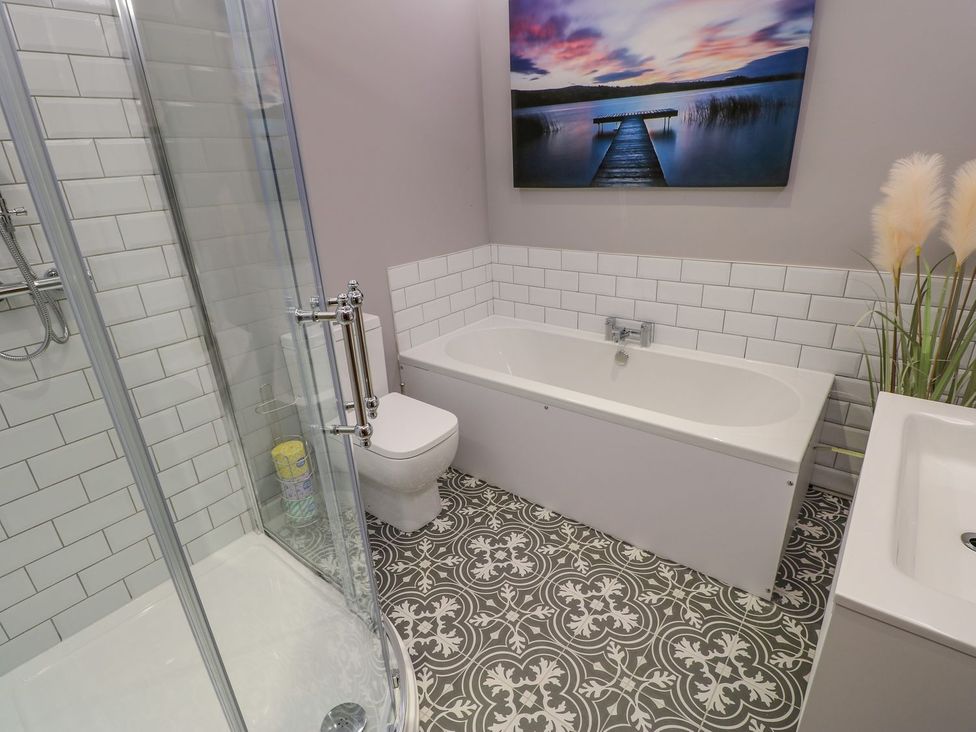 A bathroom with a bathtub, shower, toilet, and sink at Stackyard in Durham