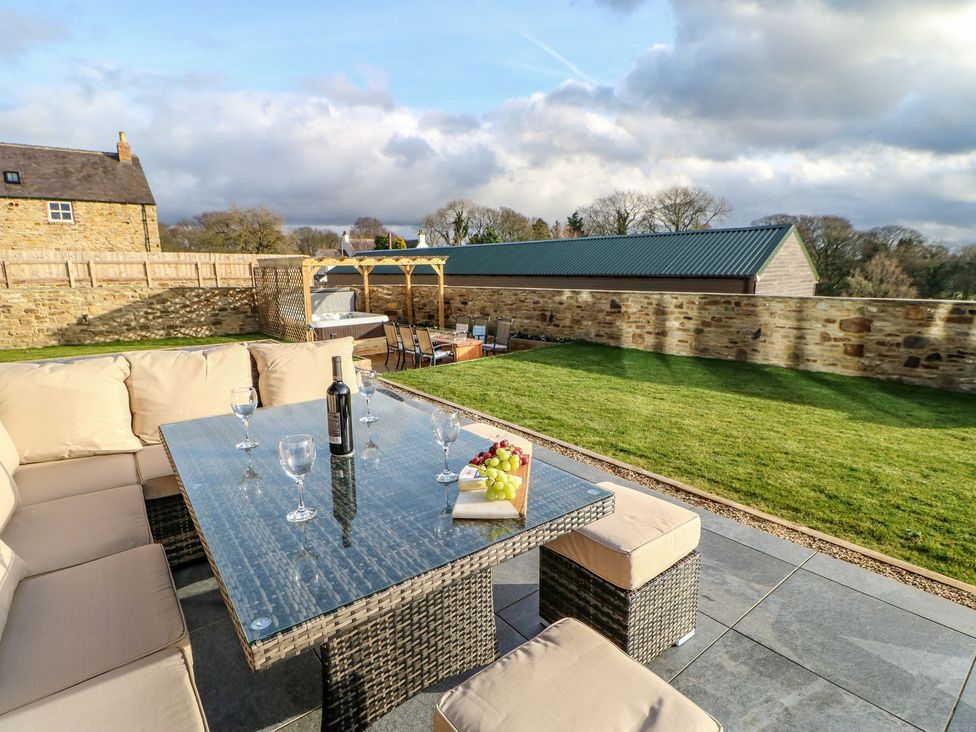 A garden with outdoor seating and a table with a wine bottle at Stackyard in Durham