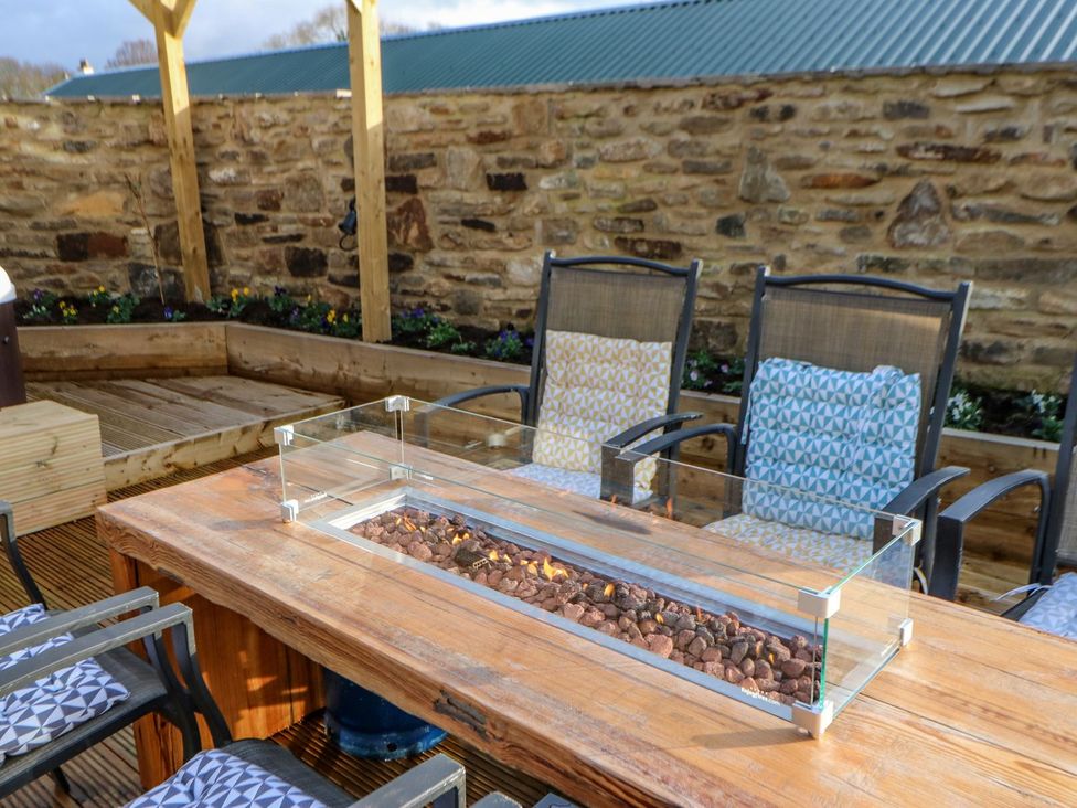 An outdoor seating area with a table and chairs at Stackyard in Durham