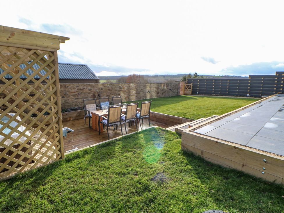 A garden with a dining set and a lattice structure at Stackyard in Durham