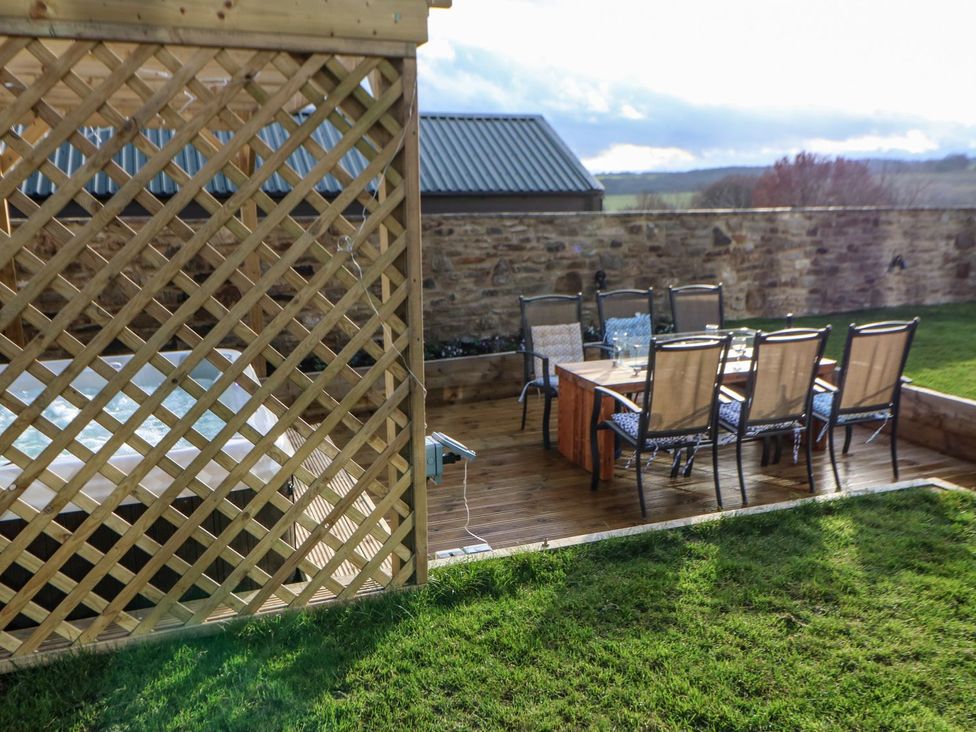 A garden with a hot tub and dining area at Stackyard in Durham