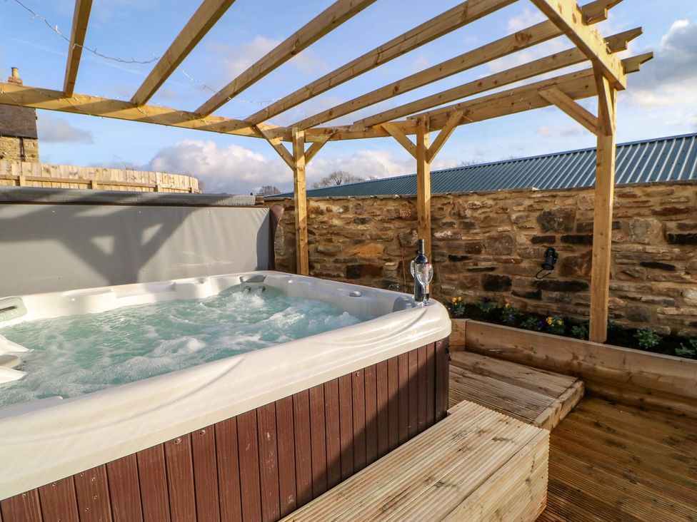 A hot tub under a wooden pavilion in the garden at Stackyard, Durham