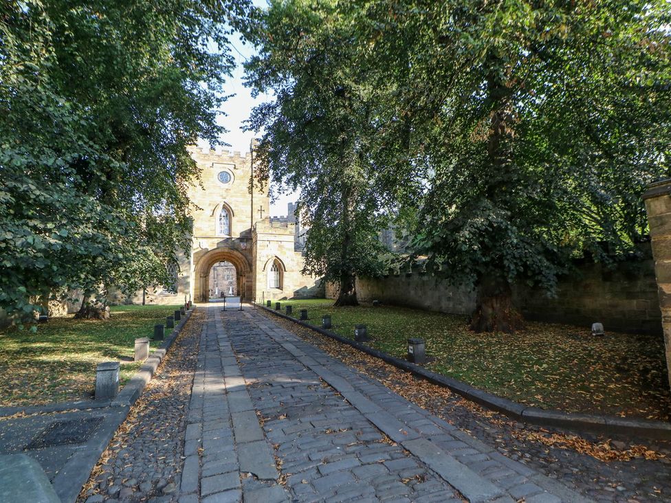 A pathway leading to an archway of a building with trees at Stackyard in Durham