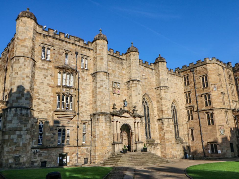 A stone building with an entrance and statue at Stackyard in Durham