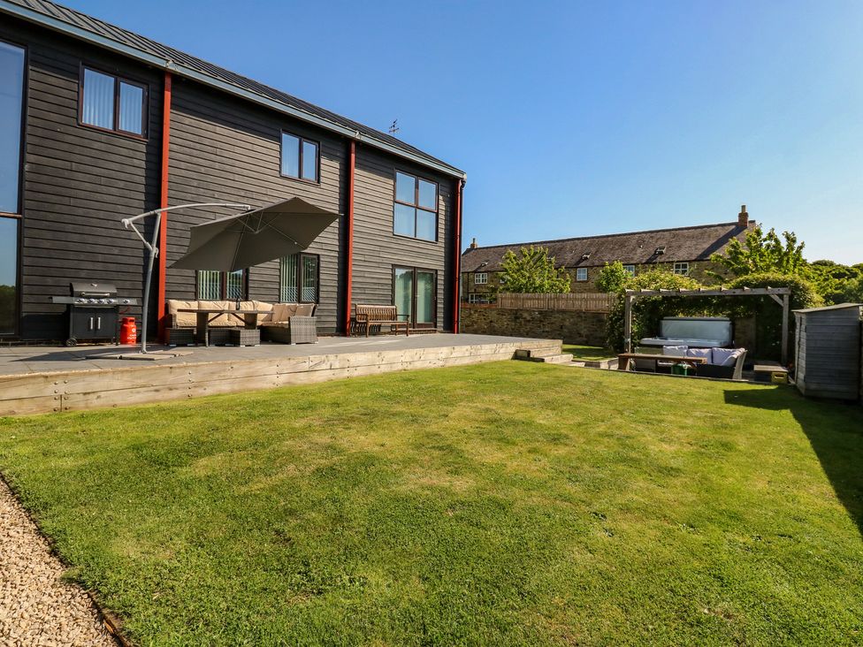 A garden with outdoor seating and a grill at Stackyard in Witton Gilbert