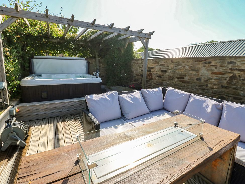 A garden with a hot tub and outdoor seating at Stackyard Witton Gilbert