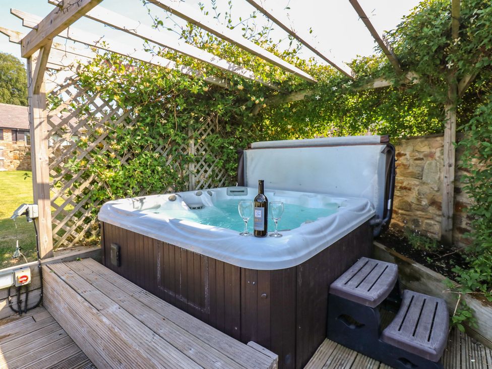 A garden with a hot tub and wine at Stackyard in Witton Gilbert