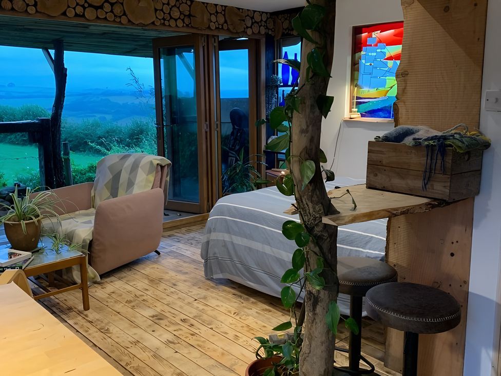 A living room with a chair and a bed at The Retreat Cabin in Llanelli