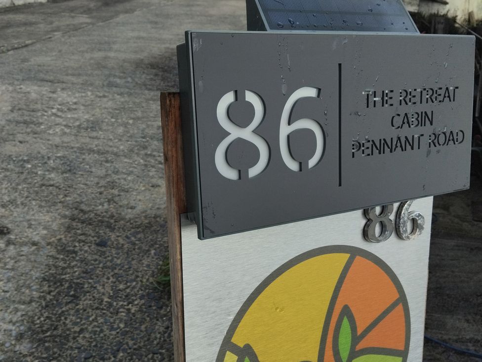 A sign displaying the address 86 The Retreat Cabin Pennant Road