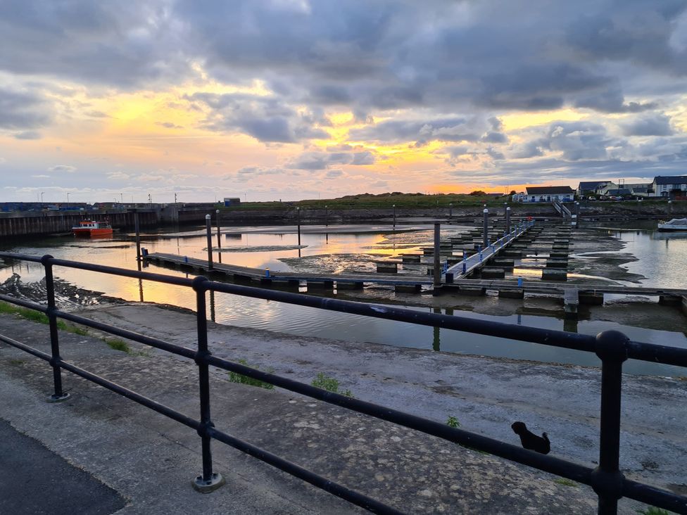 A dock with water and boats at The Retreat Cabin in Llanelli