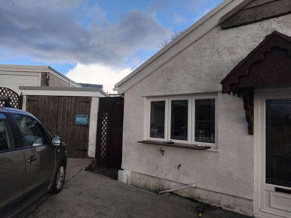 An outdoor view of a building with windows and a car at The Retreat Cabin in Llanelli