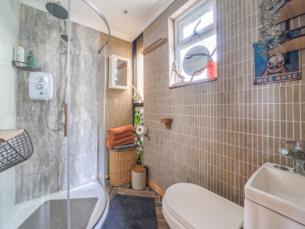 A bathroom with a shower and toilet at The Retreat Cabin in Llanelli