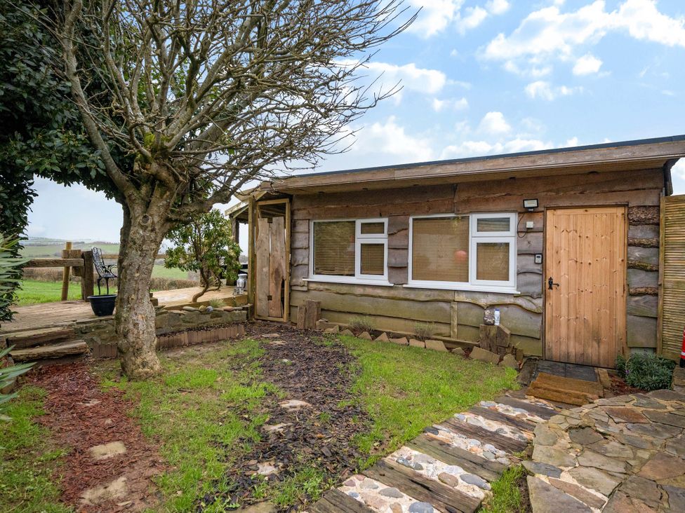 An outdoor area with a wooden cabin and pathway at The Retreat Cabin Llanelli