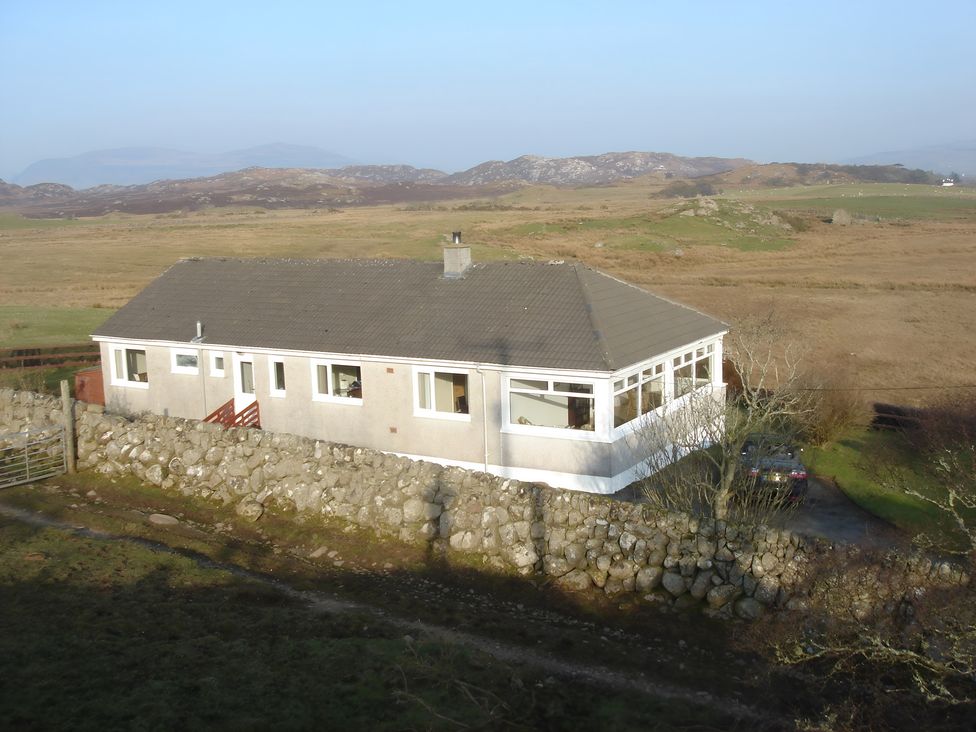 A house with stone wall and car in front at Erisgeir Isle of Mull