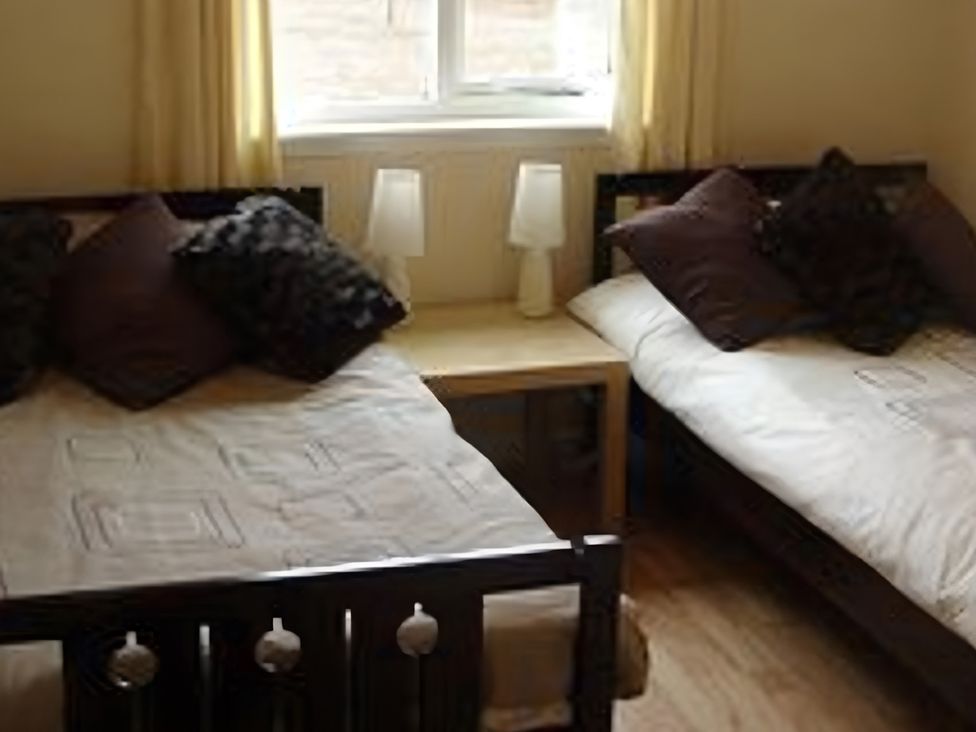 A bedroom with two beds and a table at Erisgeir in Isle of Mull